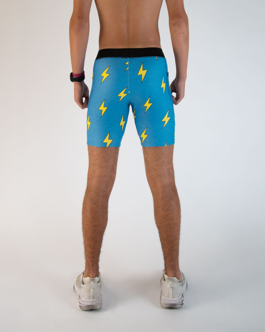 Men's blue athletic shorts with yellow lightning bolt pattern, rear view
