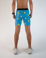 Man wearing blue athletic shorts with yellow lightning bolt pattern, rear view