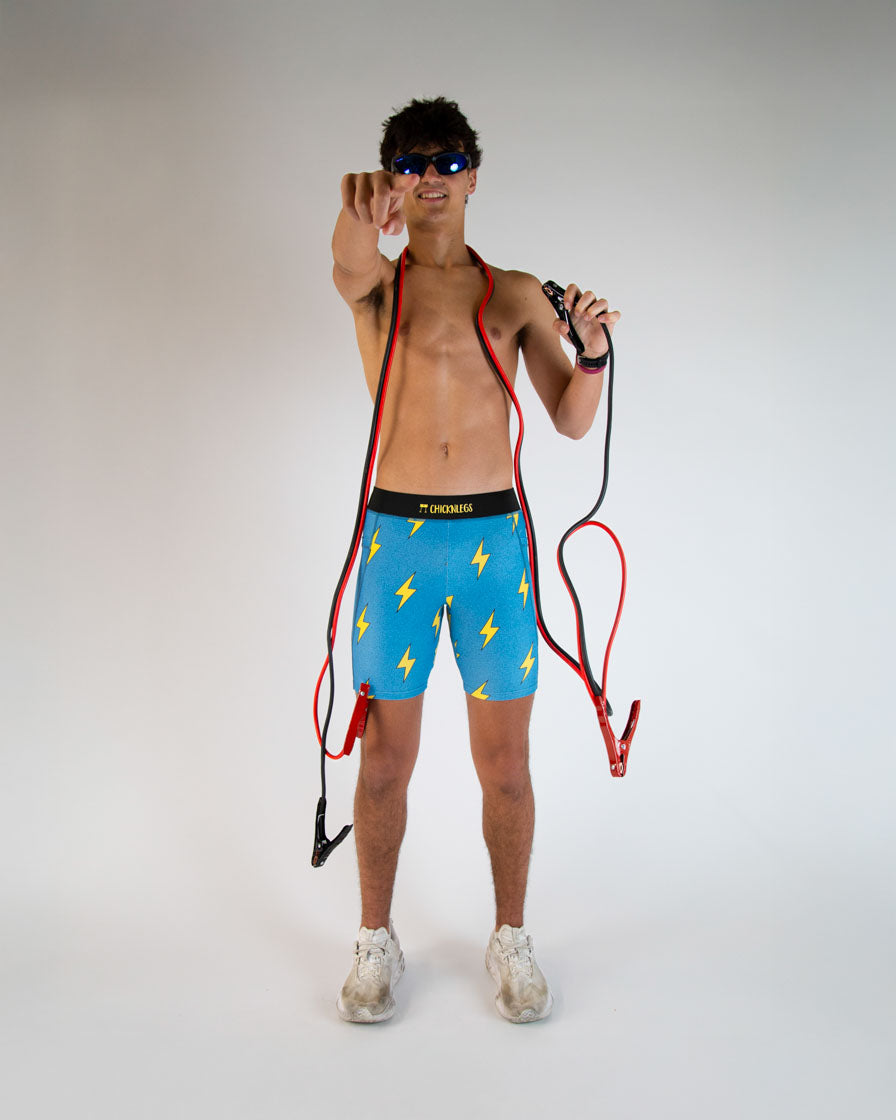 Man wearing blue shorts with yellow lightning bolts against white studio background