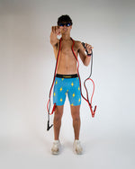 Man wearing ChicknLegs blue shorts with yellow lightning bolt pattern on white background