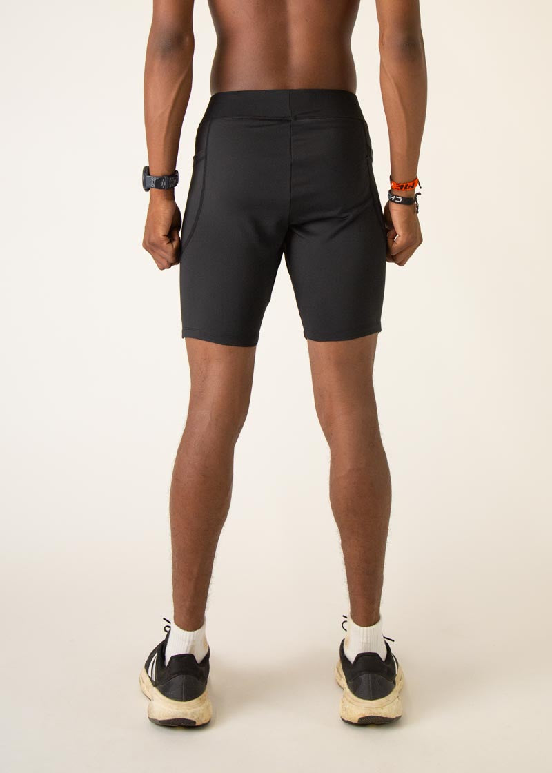 Man wearing black ChicknLegs 8-inch half tights, back view studio shot