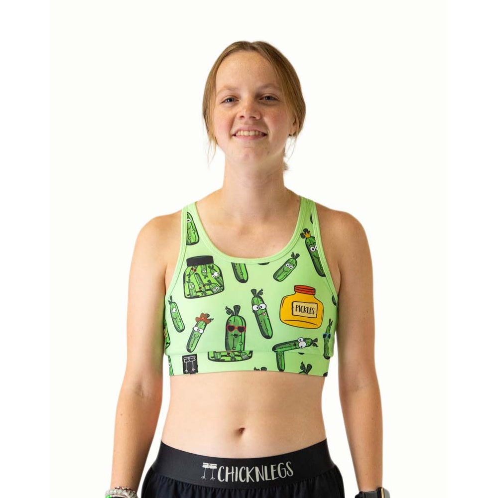 Woman wearing light green sports bra with pickle pattern design