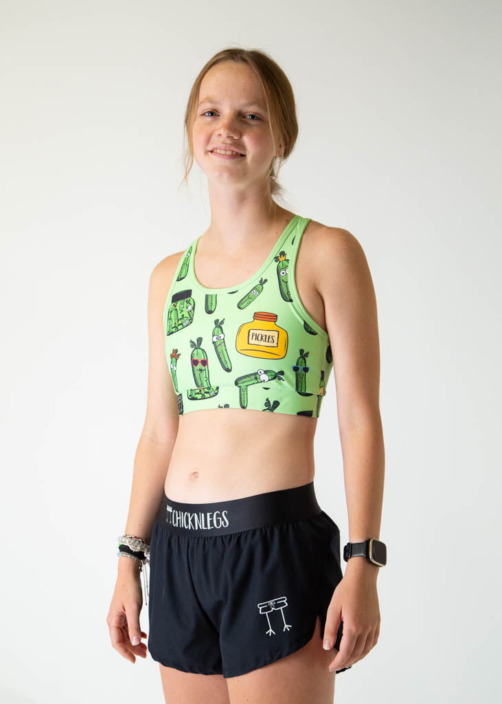 Woman wearing ChicknLegs Pickles OG sports bra in light green with pickle print