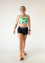 Woman wearing ChicknLegs OG Sports Bra in sea turtle print with black shorts