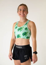 Woman wearing ChicknLegs OG Sports Bra in sea turtle print with black shorts