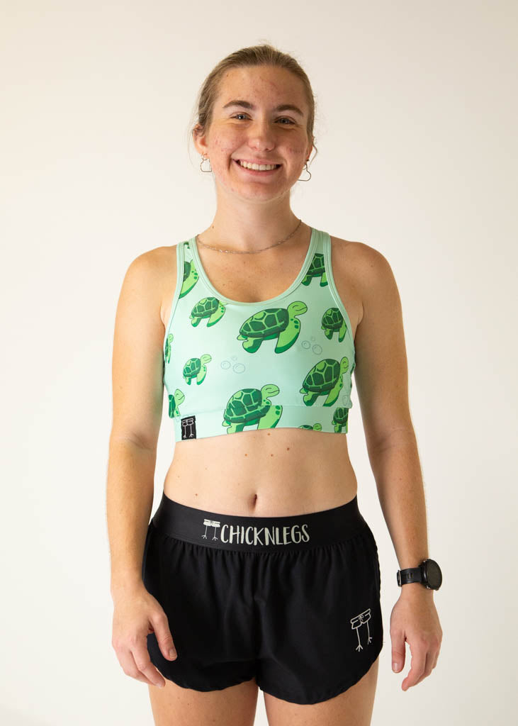 Woman wearing mint green ChicknLegs sports bra with sea turtle print pattern