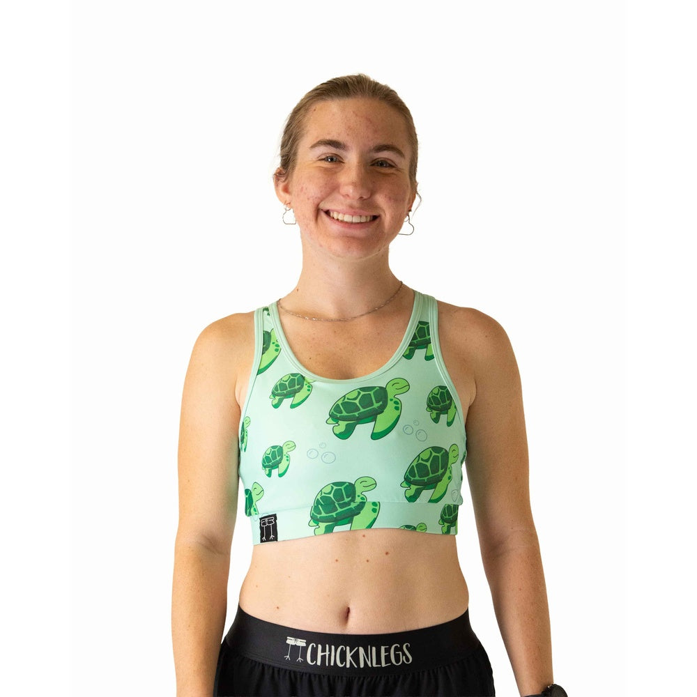 Woman wearing ChicknLegs mint green sports bra with sea turtle pattern