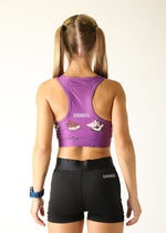 Back view of woman wearing purple ChicknLegs sports bra with cow pattern and black shorts