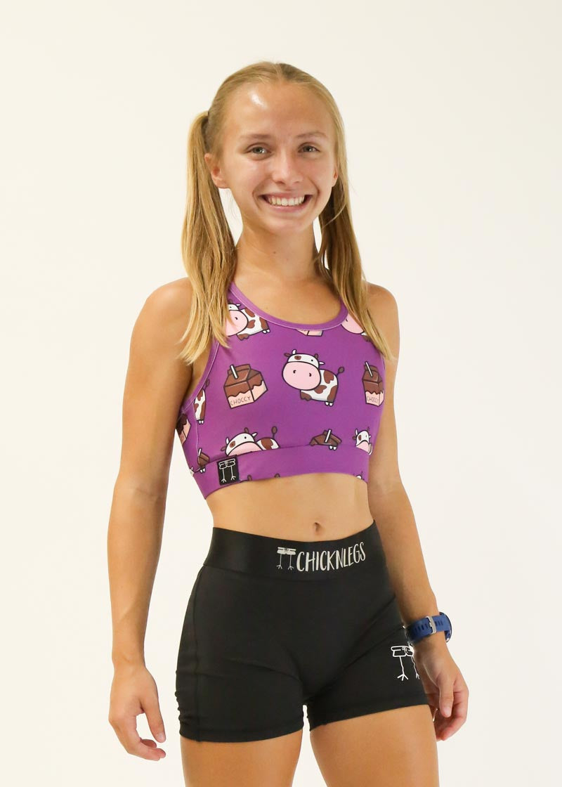 Purple ChicknLegs sports bra with cute cow and chocolate milk pattern worn by model