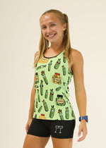 Woman wearing light green athletic singlet with cartoon pickle pattern and black shorts