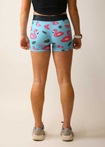 Woman wearing light blue compression shorts with pink flamingo and tropical leaf pattern