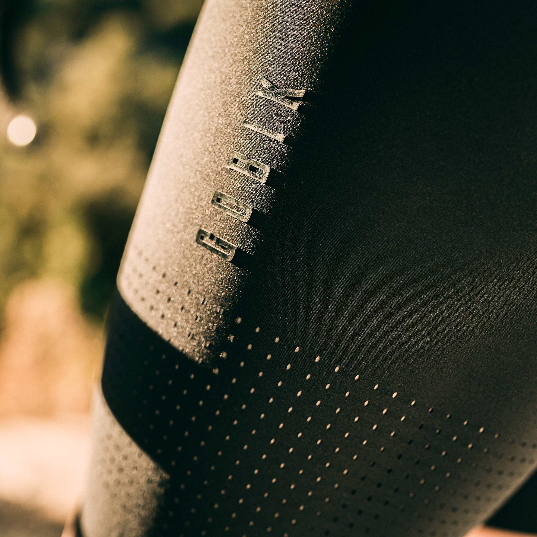 Close-up of black Gobik cycling bib shorts showing brand logo and fabric texture