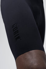 Close-up of black Gobik cycling shorts showing embossed logo on thigh
