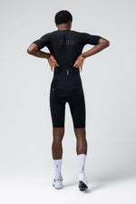 Man wearing black Gobik cycling outfit with compression shorts and jersey from behind
