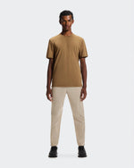 Man wearing brown On Focus-T shirt with beige pants on white background
