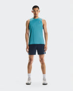 Man wearing On Core Tank in turquoise blue with navy shorts and white sneakers