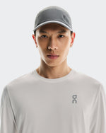 Asian male model wearing On Lightweight Unisex Cap in gray/rock color with matching shirt