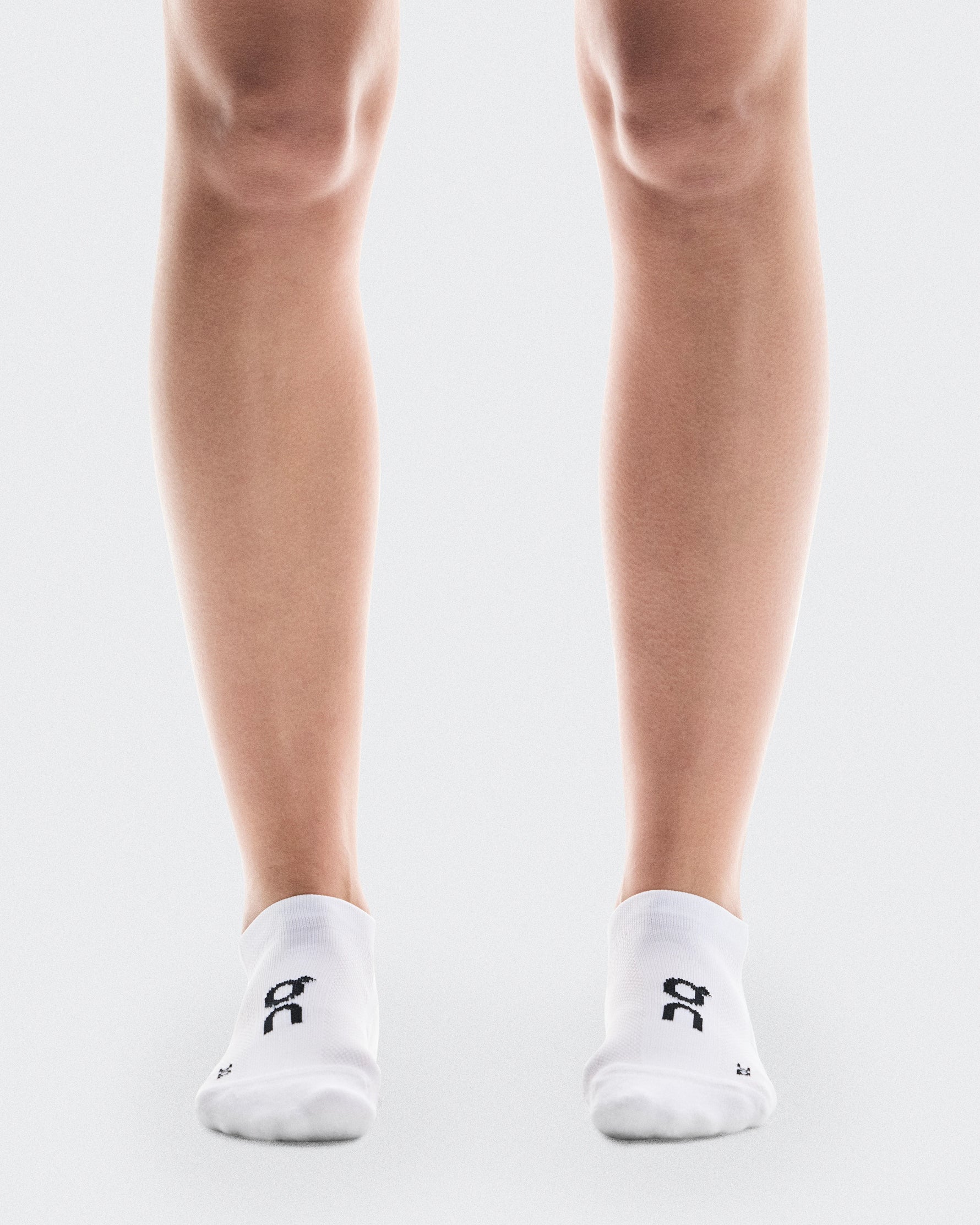 White On Core Run low-cut socks with black logo on clean background