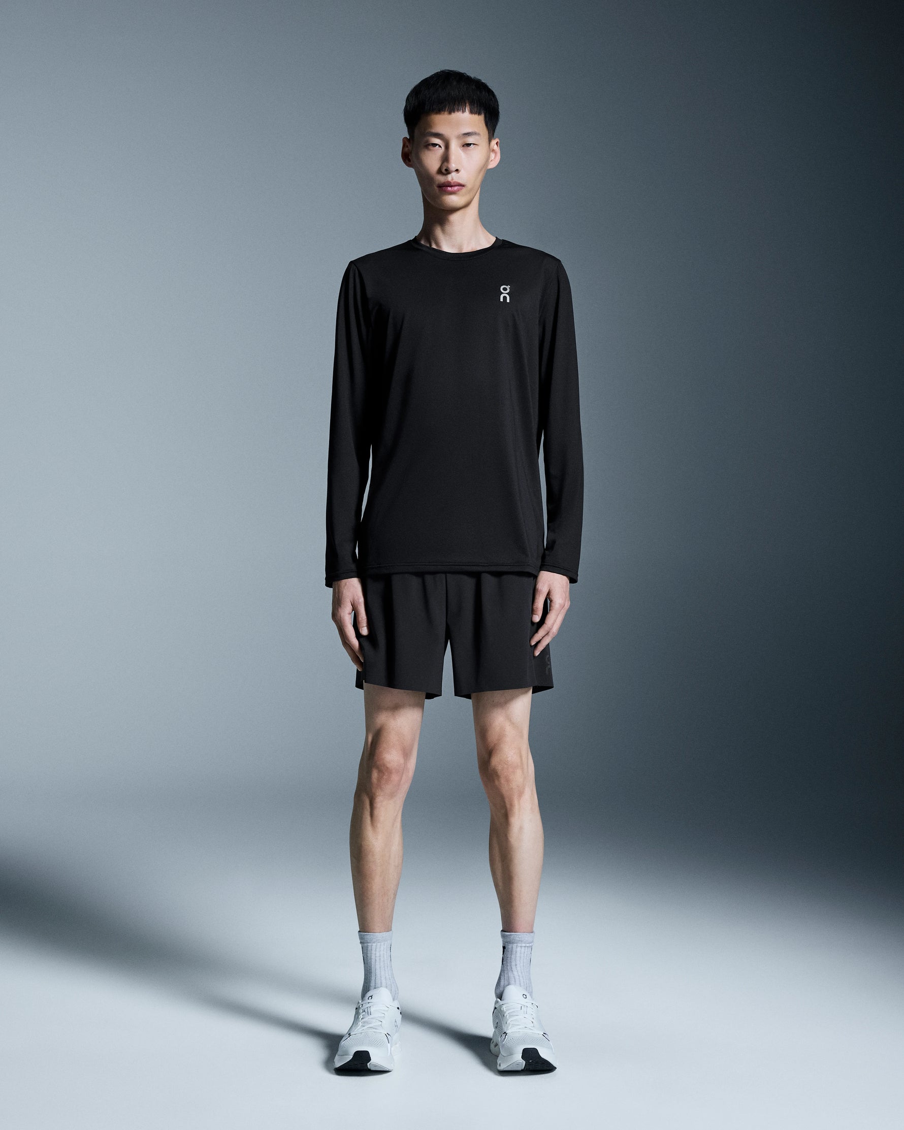 Man wearing black On 5 inch performance shorts with matching long sleeve shirt
