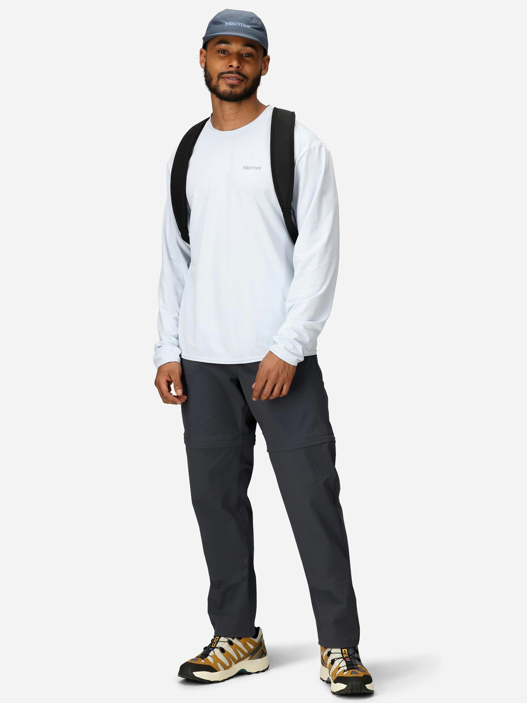Man wearing Marmot dark gray convertible pants with white long-sleeve shirt and cap