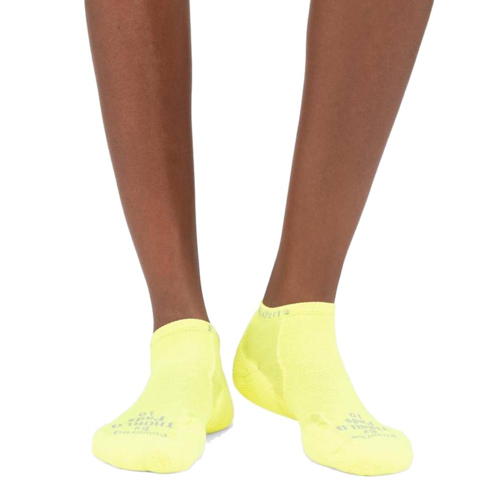 Person wearing bright yellow Experia no-show socks against white background