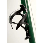 Black Eltin bottle cage mounted on green bicycle frame against white background