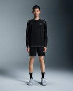 Man wearing black On 5 inch Core running shorts with matching long-sleeve shirt