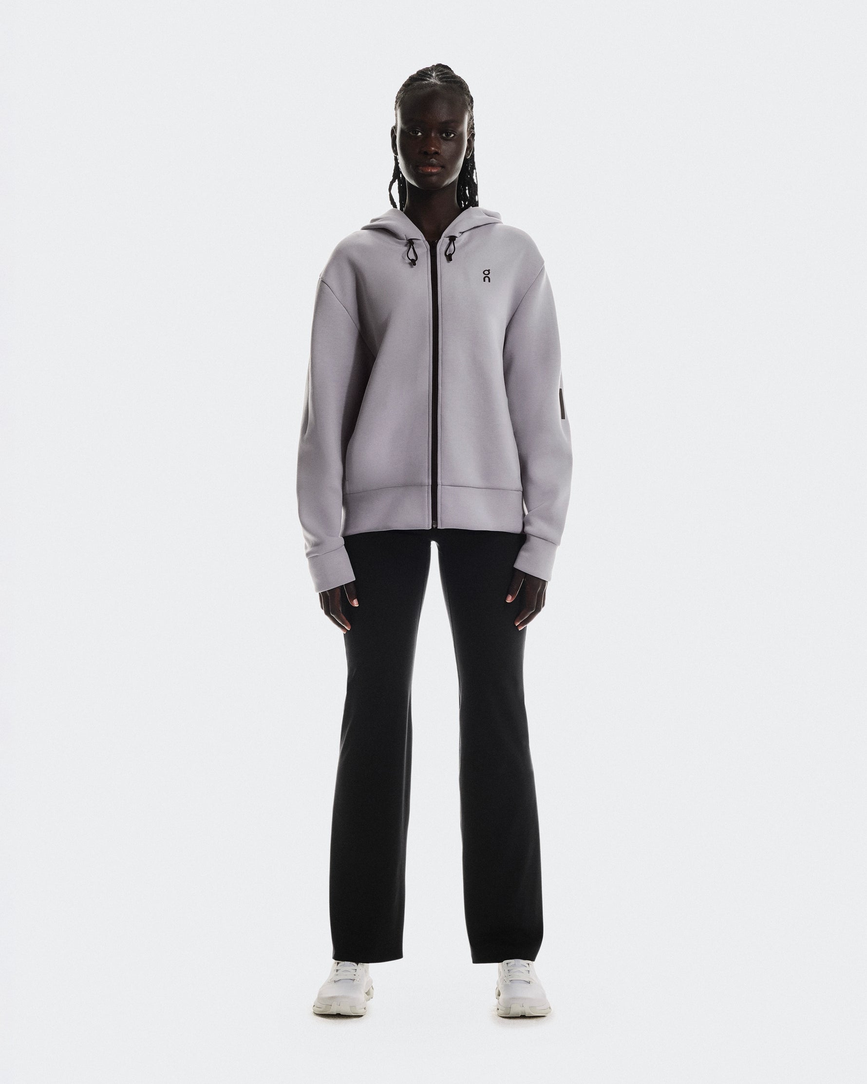 On Focus Tech Zip Hoodie in lilac worn by woman with black pants and white sneakers