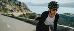 Cyclist wearing navy blue Kask Valegro helmet while riding on scenic coastal road