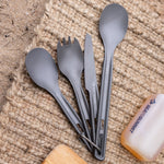 Sea to Summit grey ultralight cutlery set with spoon, fork, knife on natural fiber mat