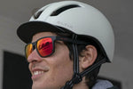 Male cyclist wearing Eltin Grant matte black sunglasses with red mirrored lenses and white Eltin helmet