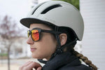 Woman wearing Eltin Grant matte black sunglasses with red mirrored lenses and cycling helmet