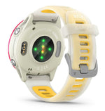Garmin Forerunner smartwatch with cream white band, yellow accents, and raspberry pink trim showing heart rate sensors