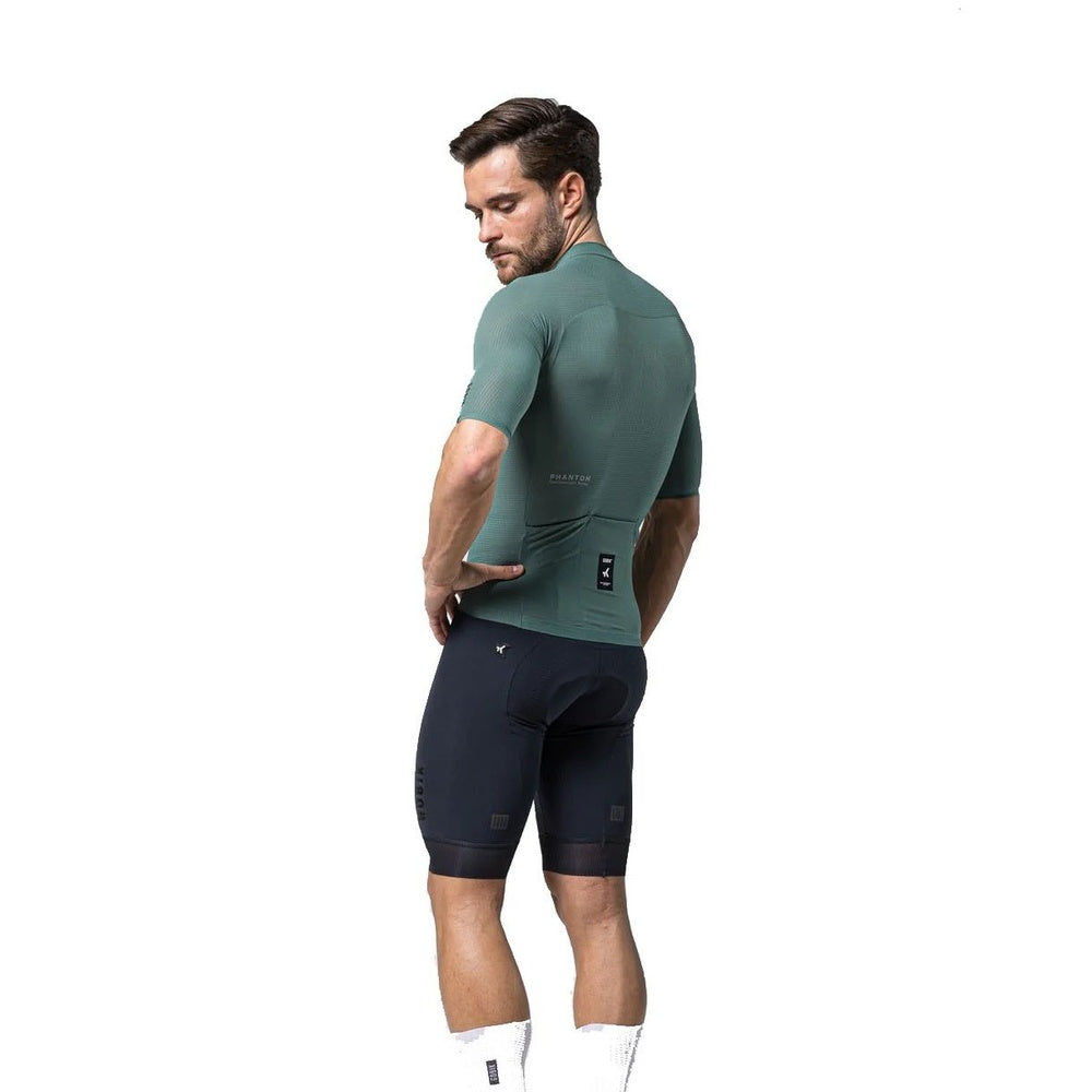 Male model wearing Gobik Phantom Jersey in bay green with navy cycling shorts