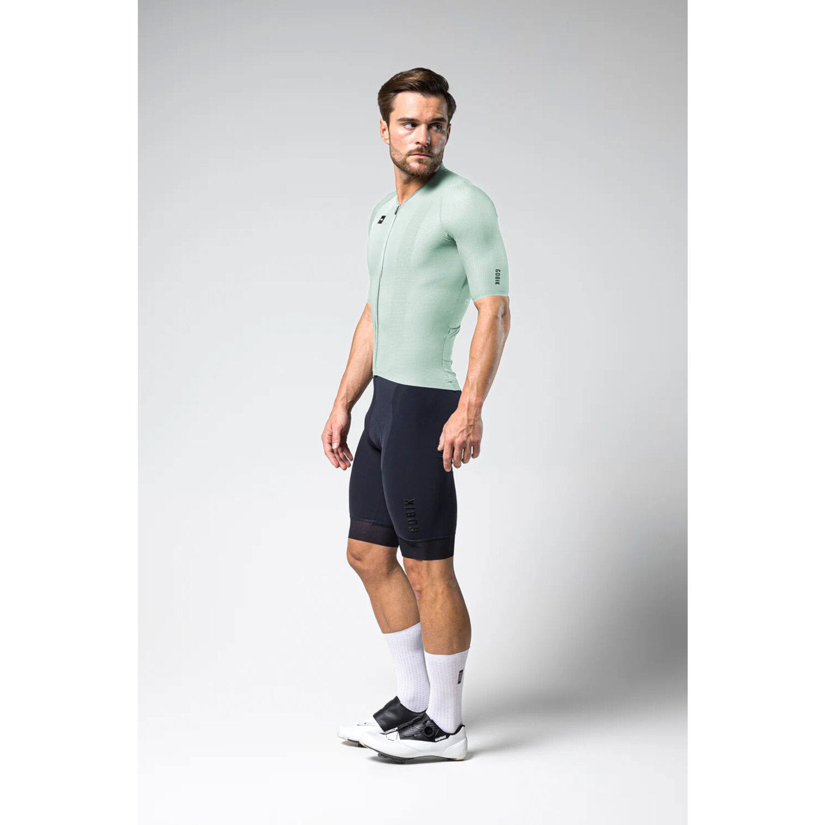 Male model wearing Gobik Phantom Jersey in light green with navy shorts