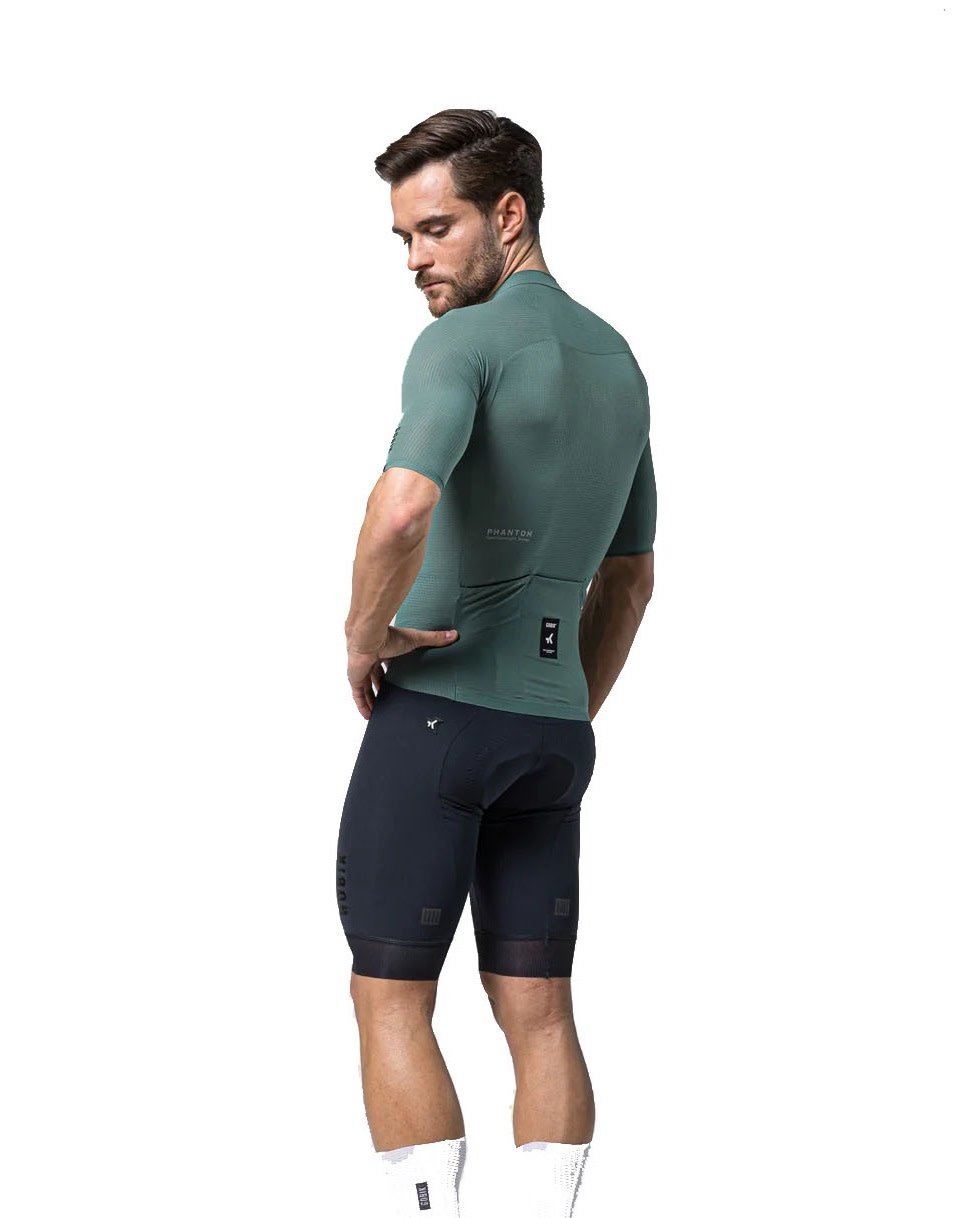 Male model wearing Gobik Phantom Jersey in sage green with navy cycling shorts