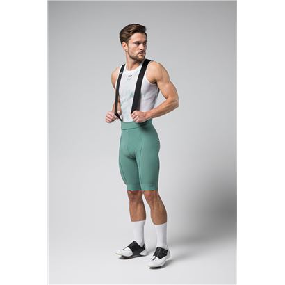 Male cyclist wearing evergreen Gobik Grit 2.0 bib shorts with white tank top