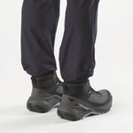 Salomon Genesis MID GTX boots worn on feet with navy pants, rear lifestyle view