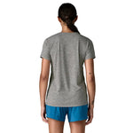 Female model wearing Patagonia Capilene Cool Daily Shirt in feather grey, rear view