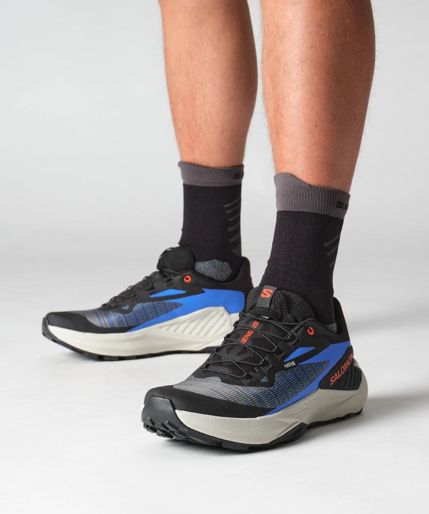 Salomon Genesis men's running shoes in black with blue accents on model's feet
