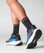 Salomon Genesis men's running shoes in black and blue colorway on model's feet