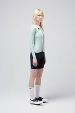 Woman wearing Gobik Avalon long sleeve cycling jersey in halcyon green with black shorts