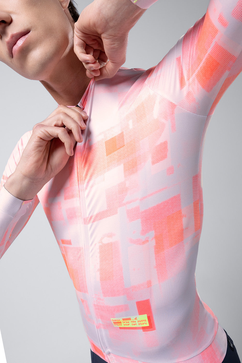 Model wearing Gobik Vanquish long sleeve cycling jersey in flamingo pink with abstract pattern