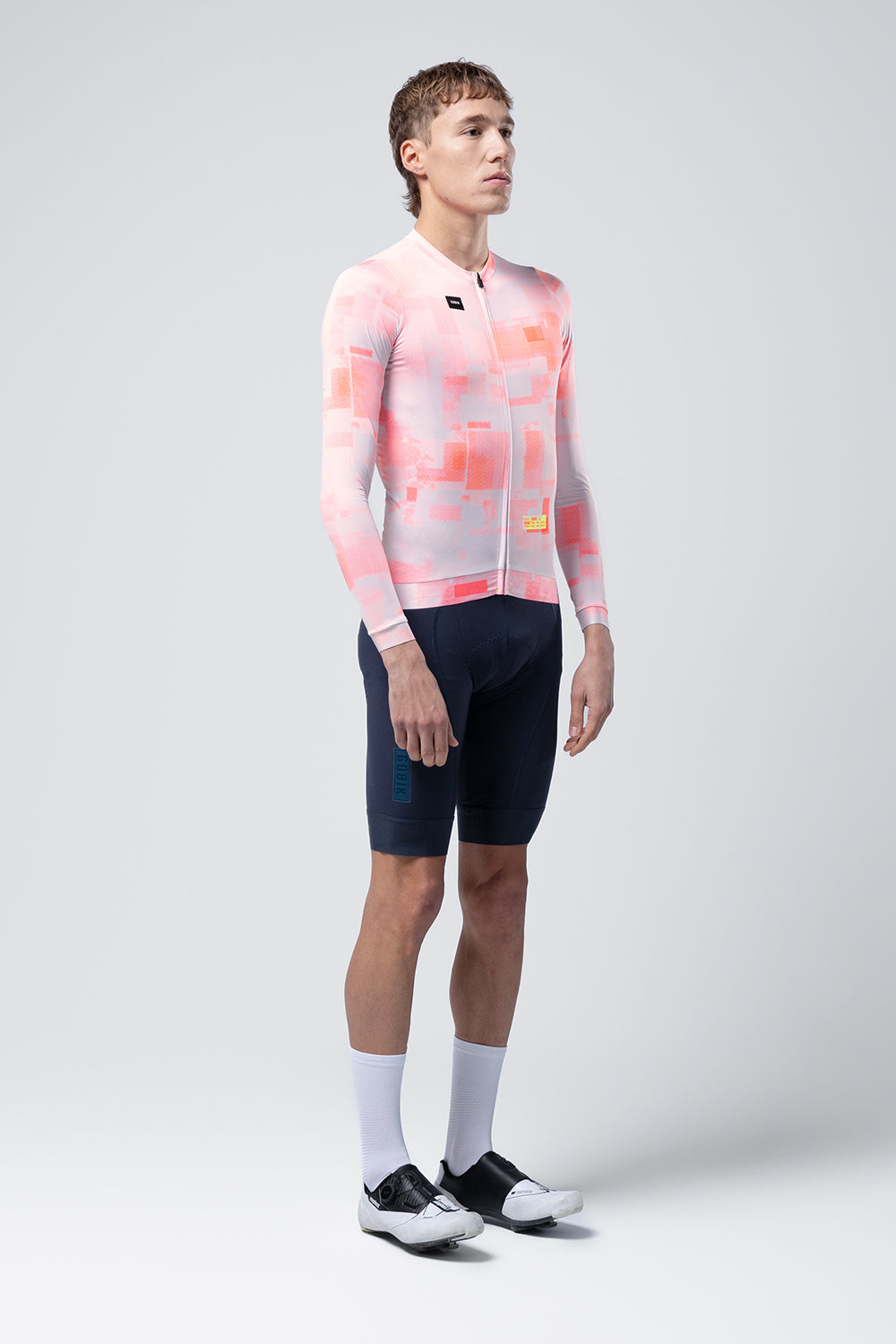 Gobik Vanquish long sleeve cycling jersey in flamingo pink pixelated pattern worn by model