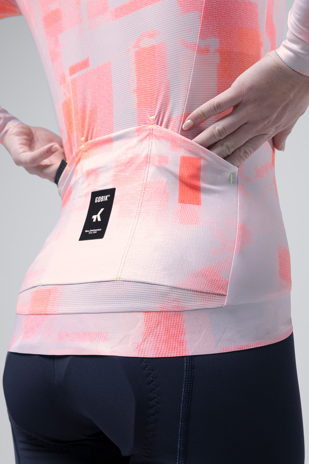 Gobik Vanquish long sleeve cycling jersey in flamingo pink tie-dye pattern on model