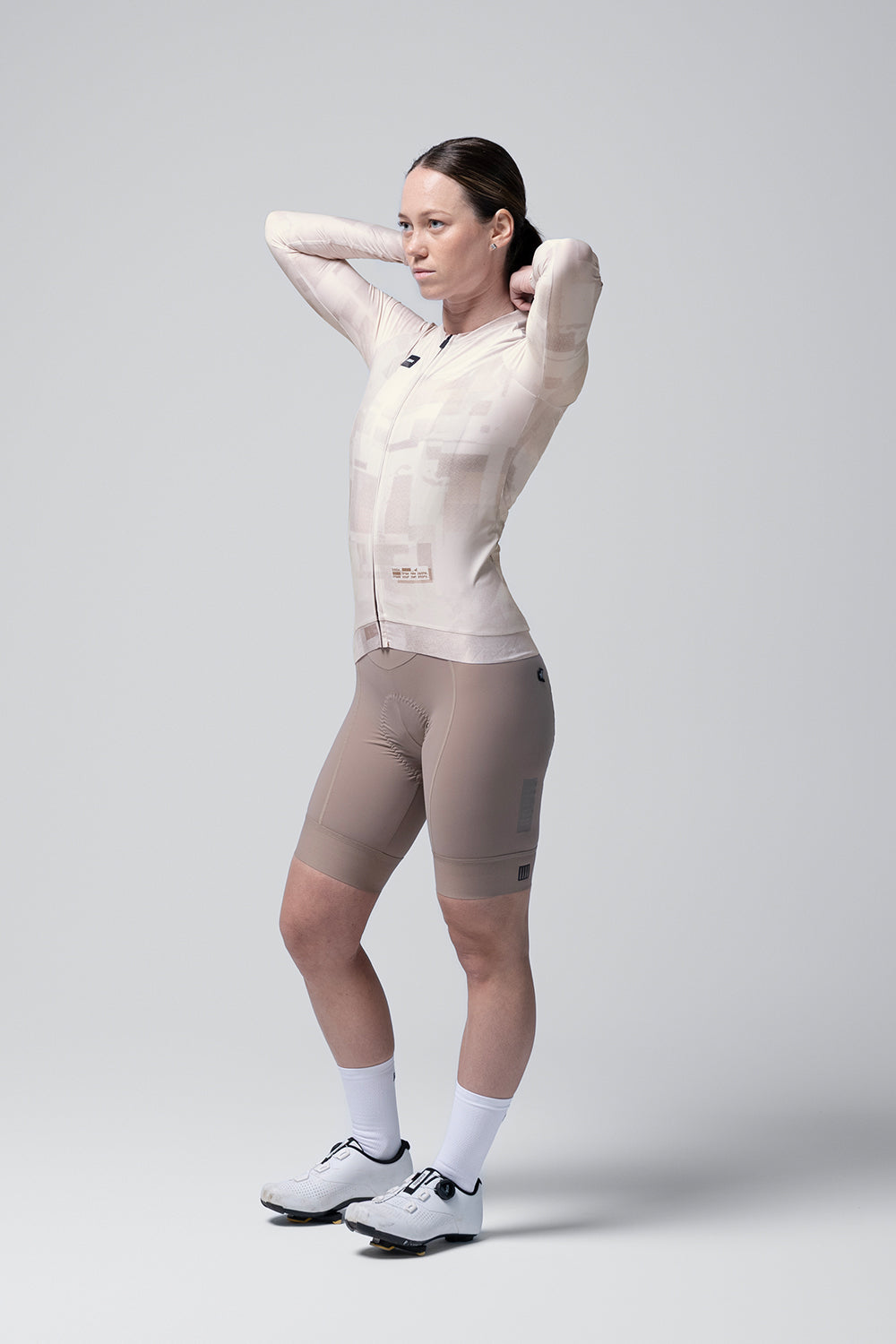 Woman wearing Gobik Vanquish long sleeve cycling jersey in whisper beige color