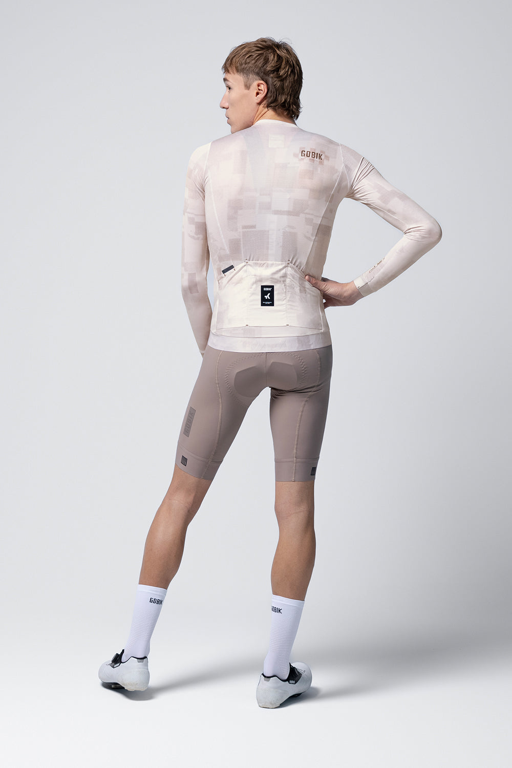 Gobik Vanquish long sleeve cycling jersey in whisper color, rear view on model