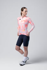 Woman wearing Gobik Vanquish long sleeve cycling jersey in flamingo pink gradient pattern
