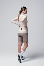 Female cyclist wearing Gobik Vanquish long sleeve jersey in whisper pink with cycling shorts