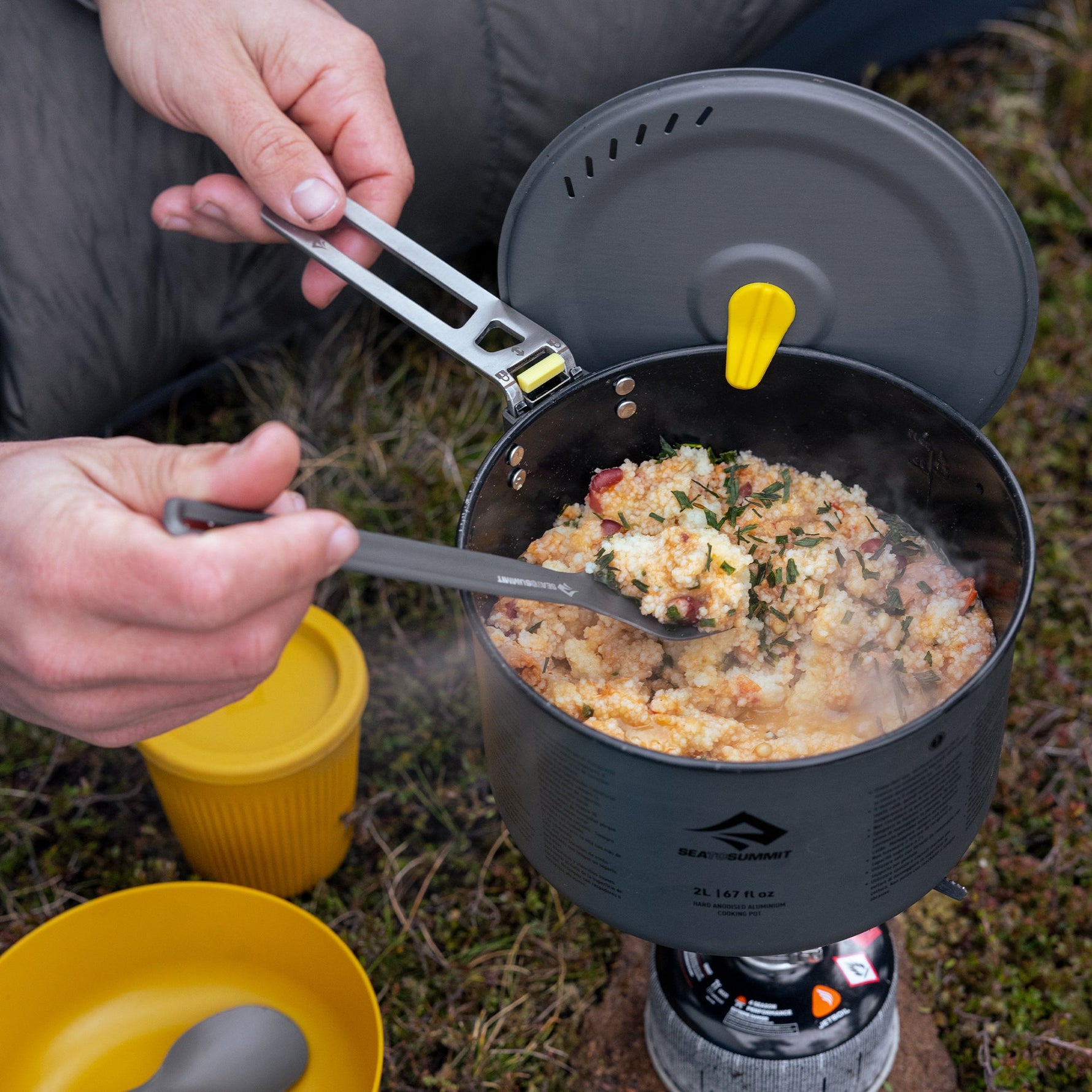 Sea To Summit ultralight spork being used outdoors with camping cookware and food